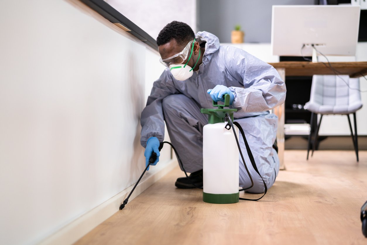 Deanza Termite technician treating exterior base of a home in Los Angeles for termite prevention