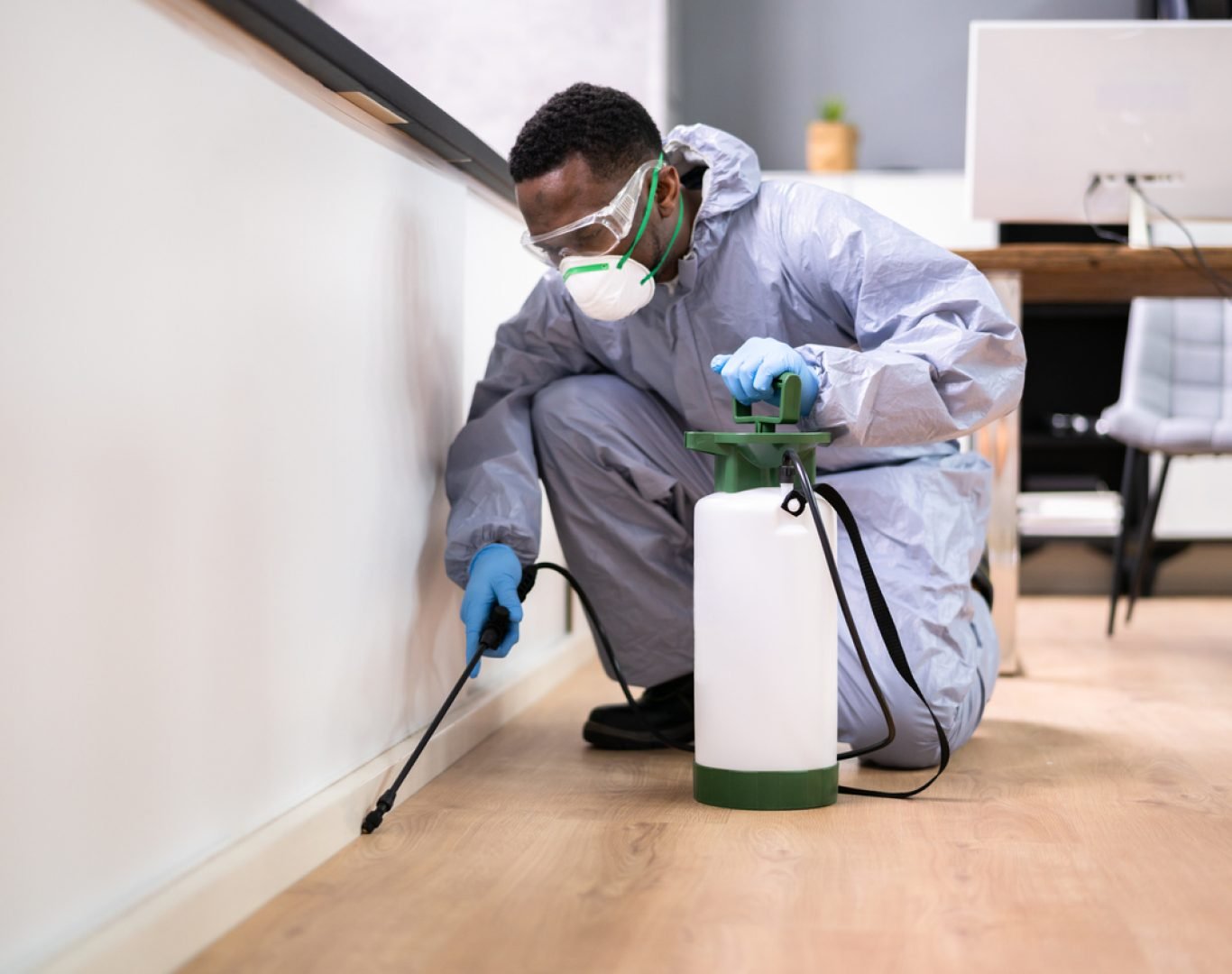 Deanza Termite technician treating exterior base of a home in Los Angeles for termite prevention